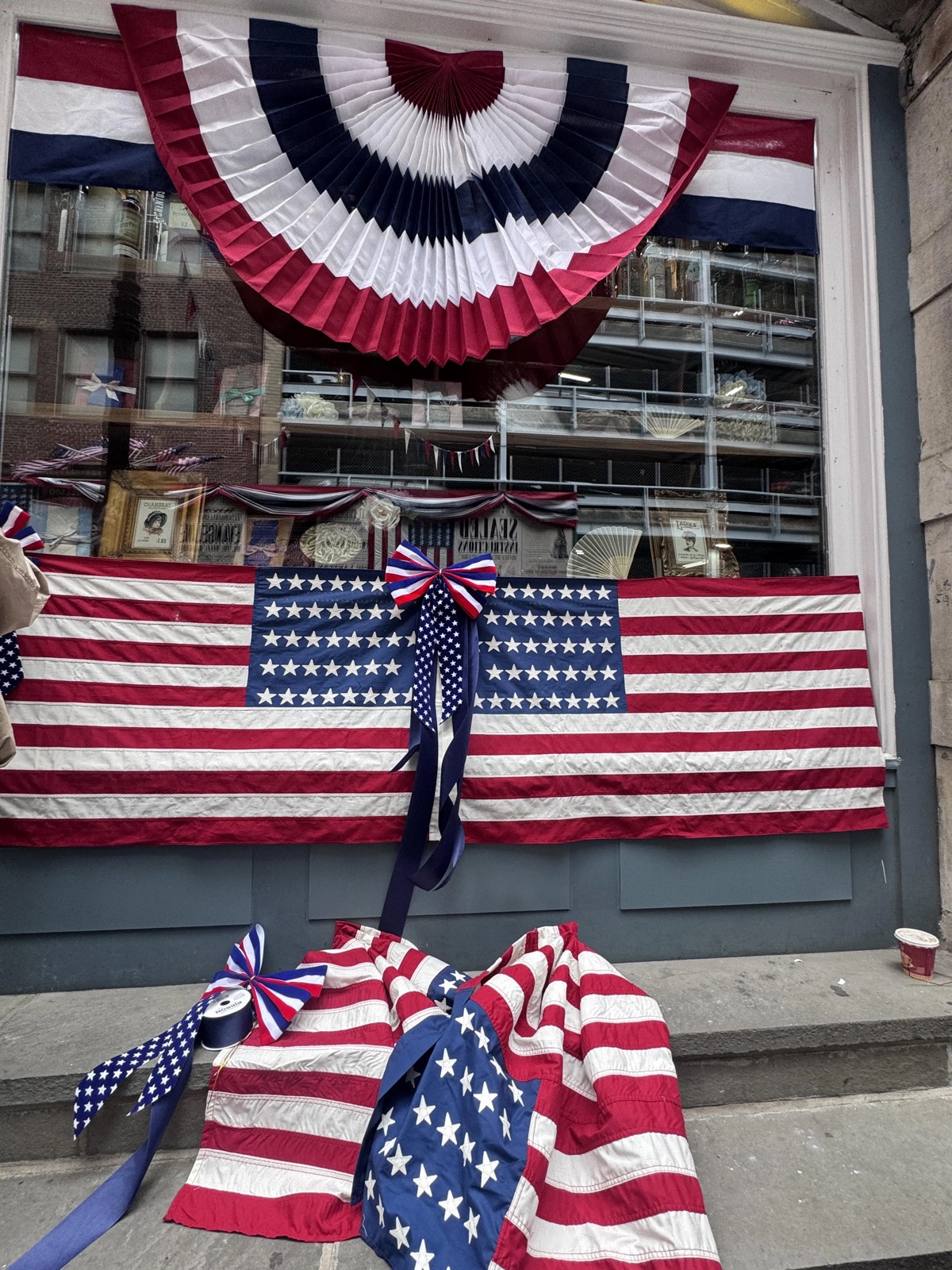 Close-up of patriotic set dressing — period-correct 38-star American flags and red-white-blue bunting rosettes